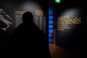Un visiteur entre dans l'exposition "Tarots enluminés"