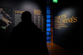 Un visiteur entre dans l'exposition "Tarots enluminés"